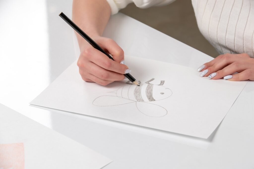 Painting Girl hand drawing a bee stripes with black pen